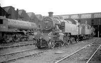 WD Austerity 2-8-0 no 90381 and Ivatt 2MT no 41206 are amongst the locomotives on shed at Wigan (L&Y) on 9 July 1960. Latterly coded 27D this shed was closed in 1964 and demolished in 1966. Commercial developments now cover the site.<br>
<br><br>[Robin Barbour Collection (Courtesy Bruce McCartney) 09/07/1960]