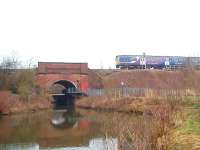 Just to the east of long closed Lea Road station, the Blackpool line crosses the Savick Brook, which in 2002 was canalised to provide a four mile link from the Lancaster Canal to the River Ribble. The bridge is made of red brick on the south side as seen here but the north side is blue brick dating from the line's quadrupling. A Northern Class 150 Sprinter heads for Blackpool. <br><br>[Mark Bartlett 06/02/2010]