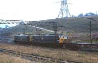 A pair of class 76 electric locomotives, with 76045 leading 76015, heading east with a freight at Dunford Bridge on the Woodhead route in August 1979<br>
<br><br>[Peter Todd 17/08/1979]