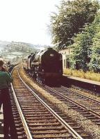 Was there ever a more photographed train than the <I>15 Guinea Special?</I> Here it is coming off the long viaduct and passing the closed station at Whalley that is packed with people wanting to see the last BR steam train on its way to Carlisle via the S&C. Few of those spectators could have imagined that not only would Whalley station eventually reopen but steam locomotives would again be regular performers on the line. [See image 20498].   <br><br>[David Hindle 11/08/1968]