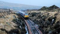 The Fort William portion of the Caledonian Sleeper approaching Cruach Rock Snowshed from Rannoch on the morning of 15 February 2010. This cutting lies about a mile north of Rannoch station. From the first winter following the opening of the line this section suffered from snow blockages. Snow fences were built down either side of the line (there is one on the left here and spoil from the cutting on the right) and a portion of the cutting was covered over with Britain's only snowshed. Stone from the cutting was used in the construction of Rannoch Viaduct.<br><br>[Ewan Crawford 15/02/2010]