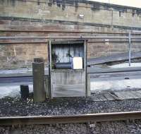 Signs of times past at Perth station. On the left is the stump of a wooden lamp post, standing alongside the remains of the old water column. The column was burnt off and plugged with part of the lamp post! (The original water column appears in many steam-age pictures taken around the north end of the station.) As for the wooden cabinet - this would originally have contained what? It currently houses a modern water heating thermostat. Photographed in February 2010.<br><br>[Gary Straiton 26/02/2010]