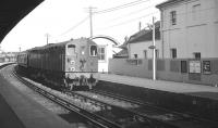 Co-Co electric locomotive no 20003 arrives at Newhaven Harbour in the 1960s with a boat train from Victoria. The sign on the fence alongside reads 'Alight here for cross-channel steamers'. Built at BRs Brighton works in 1948, no 20003 was based on a design by OVS Bulleid, although it was a modified version of the two original examples (20001/20002) produced earlier at Ashford works for the Southern Railway. Power was normally supplied via the third rail, but all three locomotives had (recessed) pantographs fitted, mainly for use when operating in Hither Green yard. All three locomotives, class 70 under BR, were scrapped in 1969.  <br>
<br><br>[K A Gray //]