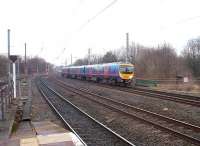 A Manchester Airport service runs into Lancaster from the north as seen from the end of Platform 3. The green railings alongside TPE 185138 mark the site of an additional bridge that carried the Green Ayre link line over Long Marsh Lane. This line had overhead catenary and was used by an EMU service to Green Ayre and Morecambe until 1966. After freight to Lancaster Power Station ceased in 1980 the trackbed was converted into a cycleway that starts by the old bridge abutment. <br><br>[Mark Bartlett 25/02/2010]