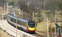 A southbound Pendolino rushes through Oubeck on its way from Lancaster to Preston on 4 March 2010 passing a Colas track machine  in the loop awaiting a path south.<br>
<br><br>[John McIntyre 04/03/2010]