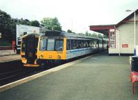 It's May 1997 and 117 308 pulls into Inverkeithing with a returning <br>
Fife Circle service, passing a 158 headed north. The 117s still have two-and-a-half years service left in them. Cigarette advertising, as seen on the platform, would last a bit longer. <br>
<br><br>[David Panton /05/1997]
