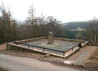 In the early hours of Saturday 17 March 1979 a section of Penmanshiel Tunnel roof collapsed during work being carried out to lower the trackbed. Of the 15 men on site at the time, two were tragically killed. It was deemed too dangerous to attempt to re-excavate the tunnel or try to recover the bodies and it was eventually decided to seal off the structure and divert the ECML via a new cutting to the west. This also necessitated realignment of the A1 trunk road. A memorial to the two men killed in the tunnel collapse, Peter Fowler and Gordon Turnbull, is seen here on 8 March 2010 looking south west from the hillside above the abandoned tunnel. [See image 28047]<br><br>[John Furnevel 08/03/2010]