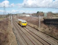 A Colas track machine has climbed the bank heading south out of Lancaster and is slowly approaching Oubeck where it is signalled into the Up Loop. The street lamps mark the line of the A6 main road, which follows the WCML for several miles south from here to beyond Galgate.  <br><br>[Mark Bartlett 01/03/2010]