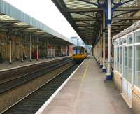 Platform view west at Warrington Central on 3 March 2010 as a Northern service from Liverpool to Manchester Oxford Road (in the hands of 142053) calls at the station. The main station building is on the right, with most of it now used by YMCA Training. <br>
<br><br>[John McIntyre 03/03/2010]