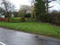 View across former Easingwold Branch level crossing on Station Road at Alne station looking towards the ECML running just beyond the farthest tree line. [See image 21801] for view in opposite direction.<br><br>[David Pesterfield 22/11/2009]