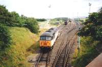 56 072 and a sibling faff about with coal wagons (if something so big can be said to faff, and if you can faff so slowly) on the Cockenzie branch in July 1995. The branch stops short of Cockenzie Power Station itself with the coal being carried into the site by a half-mile long conveyor. I'd imagine this was thought preferable to either an inconvenient level crossing over the coast road or roundabout rail route with expensive engineering works to avoid one.<br><br>[David Panton /07/1995]