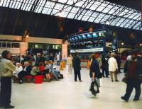 An evening at Glasgow Queen Street in July 1997 and something must be wrong: the monitors for all 7 platforms are showing the same bluescreen message and there's a lack of purpose among the customers. In fact there were signal problems causing 'severe delays and cancellations' (those inseperable twins).I think I got home by bus. <br>
<br><br>[David Panton /07/1997]