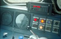 The driving position inside driving trailer 9709 at Glasgow Queen Street in 1989 with the train about to leave for Aberdeen. I'm not sure which 477 was in the rear. The panel of eight lights and buttons to the right are labelled (left to right, top and bottom); Engine Stopped/Line Indicator, Wheel Slip/Indicator, General Fault/Indicator, Fire Alarm/Test, Train Heat/Off, Train Heat On/Indicator, Train Heat/On, Fire/Extinguish. These driving cars were converted from mark IIf brake coaches and control of the locomotive was carried via the coaches' lighting circuit (which allowed extra coaches to be inserted as required). (Any corrections and more comments on that would be welcome - for instance I seem to recollect that these trains were built to a very tight budget as BR did not consider Edinburgh-Glasgow an InterCity service.) [Access with thanks to the driver.]<br><br>[Ewan Crawford 07/09/1989]