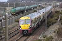  <br>
334037 leads a Glasgow Central - Ayr service past 66185 waiting to leave Prestwick fuel depot with the 6N44 empties for Grangemouth on 19 March 2010.<br><br>[Bill Roberton 19/03/2010]