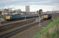 Dundee looking east at the station. A train sits in the down loop (hauled by 47284 seemingly with 26037 sitting on top of it!) and a train for Edinburgh (hauled by 47004) is just leaving. The train in the loop was to head south over the bridge a few minutes after the one on the right.<br><br>[Ewan Crawford //1989]