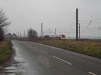 Cross Country Voyager speeds south by the rear of the GBRF Tyne Dock to Drax Power Station loaded working, with one of the sleeping carriages at The Sidings Hotel at Shipton north of York visible on left.<br><br>[David Pesterfield 25/03/2010]