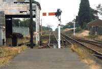 Standing at the end of the platform at North Walsham station looking south towards Norwich in 1996. The Carless oil terminal compound is visible on the left of the line through the patchwork of the old wooden goods shed.<br><br>[David Pesterfield 31/07/1996]