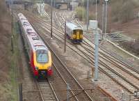 The Ormskirk <I>Bubble Car</I> bears right and right again at Farington Curve Junction as a Voyager heads for Birmingham on the Up Fast. Northern 153360 will take the single line to Midge Hall, the former main line to Liverpool, through the grey bridge on the far right.<br><br>[Mark Bartlett 05/04/2010]