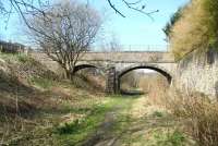 Just north of Kilnknowe Junction, with the Peebles line about to diverge west, this double-arch road bridge carried Kilnknowe Place over the formation. The single line for Peebles ran through the arch on the left, with the Waverley Route using the wider span on the right. View north in  April 2010, some 41 years after closure - during which time nature seems to have reclaimed much of the old cutting. <br>
<br><br>[John Furnevel 11/04/2010]