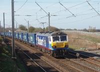 The pantograph on Stobart liveried 92017 is rising as it approaches Hest Bank level crossing where the wires are set high to provide clearance. The very long train was composed almost entirely of Tesco containers, with just a few empty flats at the rear, demonstrating DB's confidence in the Class 92 Co-Co electric's hauling capabilities over the climbs ahead. <br><br>[Mark Bartlett 14/04/2010]