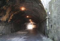 Approximately half a mile north of Galashiels station the Waverley line ran under the A7 through Ladhope Tunnel. The view looks south through the tunnel, now part of a walkway/cycleway, on 11 April 2010. Note the original skew-arch roof construction at this end and the more recent modifications at the south exit to cater for local road improvements. [See image 28676]<br>
<br><br>[John Furnevel 11/04/2010]