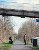 Simon Longland - whose 1992 motor-bike trek to survey all the surviving structures of the Waverley Route started the process which should culminate in the 2015 Borders Railway re-opening - admires the surviving steam deflectors below the pedestrian footbridge spanning the railway at Langlee at the south east end of Galashiels, on 2nd April. Given the design of the bridge, and the steam-related deflector requirement, this adornment must have been created in the early to mid-1960s. Beyond the bridge, a stretch of the old solum has been infilled and will need to be re-excavated. [See image 46466] <br><br>[David Spaven 02/04/2010]