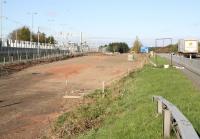 View west at Uphall on 2 May 2010. The strip of land between the new eastbound platform and the M8 motorway has now been cleared and prepared for road access, additional parking etc, while at the far end work continues on widening the bridge over the B8046 Station Road [see image 28761].<br><br>[John Furnevel 02/05/2010]