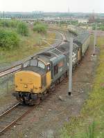 In 1989 there was still one locomotive hauled daylight service from Glasgow to Fort William. In the morning this ran south to Glasgow Central which led to a route via Glasgow Central (Low Level) and Rutherglen to reach the High Level station. The train, four coaches hauled by 37413 <i>Loch Eil Outward Bound</i>, is seen about to join the mainline at Rutherglen off the Switchback/Argyle line. In the afternoon it returned north. This service was something very much along the lines of what <b>Whestrail</b> would like to introduce. The track to the left was part of the Rutherglen Training Centre and this view has changed as the centre has closed and the M74 extension is under construction over the lines here.<br><br>[Ewan Crawford //1989]