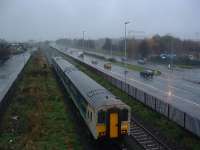 An ex-Bangor Belfast-bound DMU leaves Sydenham in 2003. A Harland and Wolff crane is just visible through the rain.<br><br>[Ewan Crawford 17/11/2003]