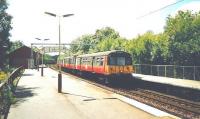 A class 303 bound for Glasgow Central stands at Williamwood in July 1999, while another example in the background heads for Neilston.<br><br>[David Panton /07/1999]