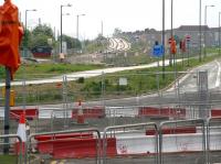 A Sunday morning view looking east towards Broomhouse on 23 May 2010, showing the tracks that will eventually carry trams over the B701 Broomhouse Road. On the horizon the outline of Edinburgh Castle can just be made out through the haar. To the left the catenary of the E&G main line runs parallel with the tram route at this point. Both will continue on to Edinburgh Park station, approximately half a mile behind the camera, at which point the trams will then turn north, crossing the E&G on a new flyover, before heading for Edinburgh Airport. [See image 29068]<br><br>[John Furnevel 23/05/2010]