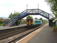 Arriva Trains Wales single unit DMU 153320 waits under the  footbridge at Craven Arms for right of way prior to running forward onto the 'Heart of Wales' Line with the 14.36 service to Swansea.<br><br>[David Pesterfield 25/05/2010]