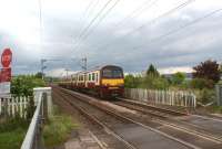 320302 heads west from Cardross at Geilston LC on 29 May 2010. The site of the former crossing keepers cottage and garden can be seen to the right of the train.<br>
<br><br>[John McIntyre 29/05/2010]