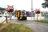 Wet day at Strathcarron on 28 September 2009 as the 1101 ex-Inverness pulls away from the platform and crosses the A890 with approximately 20 miles to go to reach its final destination at Kyle of Lochalsh. <br><br>[John Furnevel 28/09/2009]