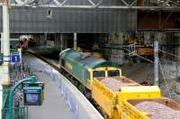 Scene during the major works at Waverley in 2006 as Freightliner 66607 creeps into the former platform 1 at the east end of the station with a ballast train. Note the access road created on the right for plant and materials coming in from Calton Road with a transporter/lifting unit in the process of leaving the station.<br><br>[John Furnevel /02/2006]