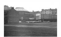 On 15 February 1848 the Caledonian opened its Edinburgh terminus at Lothian Road. This temporary facility was intended to last a fairly short time pending completion of a much grander structure off to the left that was to become Princes Street station. In fact Lothian Road passenger station was in operation for just over 22 years with closure coinciding with the eventual opening of Princes Street on 2 May 1870. It was from Lothian Road station that Edinburgh's first through service to London commenced in February 1848, some two years prior to the first ECML services which followed the opening of the Royal Border Bridge by Queen Victoria in 1850. After the transfer of passenger services to the new Princes Street station, the site was subsequently put to use as a goods depot. This view around 1972 shows most of the area now cleared with a bus heading south along Lothian Road between the Usher Hall and Alexander's car showroom opposite. <br>
<br><br>[Bill Jamieson //1972]