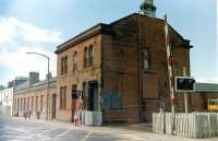 The main station building at Ardrossan Town from the south in 1985, photographed looking over Princes Street level crossing. A DMU can be seen standing in one of the bay platforms on the right.<br><br>[Colin Miller //1985]