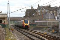 A Voyager for Birmingham New Street passes Carnforth on 19 June 2010. The WCML platforms were removed prior to electrification, resulting in passengers for the north having to first go south to Lancaster. Since introduction of the Virgin VHF timetable options for connections at Lancaster have been reduced and a lengthy detour via Preston can be necessary. The original station building on the WCML up platform here remains in use today as the booking office and a number of small retail outlets. The buildings on the platform between the WCML and Furness lines have been restored and now house a refreshment room and visitor centre.<br><br>[John McIntyre 19/06/2010]