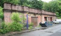 Frontage of the former L&D station at Bowling (closed in February 1951) looking east along Scott Avenue on 8 June 2010. The 1896 building is currently used as lock-up garages and storage facilities. The path leading up to the trackbed, now a walkway/cycleway, is to the left of the skip. [See image 29943] <br><br>[John Furnevel 08/06/2010]