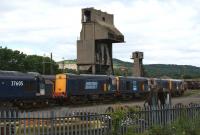 Looking at the locomotives stabled next to the station at Carnforth on 19 June 2010 you may think that DRS had opened a new depot, but the yard area around the former steam shed (latterly 10A in BR days) is still part of the West Coast Railway Company. Three Class 37 and four Class 20 locos are currently stored on the site in the shadow of the coal and ash towers.<br>
<br><br>[John McIntyre 19/06/2010]