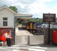 The curious little separate Looe branch station, Platform No.3 at Liskeard, that is a short walk from the main line platforms. The guard of the branch train is having a short break between services as 153368 waits at the buffers before dropping down to the East Looe valley again. [See image 11870] <br><br>[Mark Bartlett 15/06/2010]