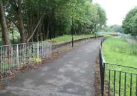 View west from the surviving platform of Dalry Road station on 6 June 2010. Part of the Western Approach Road, which now occupies the former route of the Caledonian main line from Princes Street station, is visible through the trees on the left. The line north is starting to curve away here before crossing Dalry Road itself to reach Dalry Middle Junction [see image 35358].  <br><br>[John Furnevel 06/06/2010]