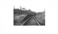 Greenmount station, looking towards Holcombe Brook, and probably taken around 1960 when freight services to that village had ceased and the line cut back to Tottington. The platform has since disappeared and the cutting has been partially filled in although the bridge parapet is still visible on the road. The Kirklees cycle trail starts at the bridge and then follows the old approach path down to the trackbed then south from the old station area to Tottington and Woolfold. [See image 45152] for the same location today. Photo courtesy of Bury Historical Society.  <br><br>[W A Camwell Collection (Courtesy Mark Bartlett) //1960]