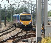 First Trans Pennine Express 185147 snakes across the WCML down line to join the up line after departing from Carnforth on a Barrow - Manchester Airport service on 19 June 2010.<br>
<br><br>[John McIntyre 19/06/2010]