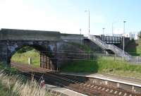 View south over Musselburgh station on 27 June 2010. From left to right are the bridge carrying Whitehill Farm Road over the ECML, the access stairs to the down platform and station car park, the plate girder bridge that once spanned the goods lines to Niddrie West and, in the background, Queen Margaret University campus.<br><br>[John Furnevel 27/06/2010]