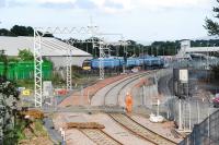 A service for Bathgate takes the route to the terminus. This followed hot on the heels of a ballast train which, having entered the line under construction, paused out of shot behind the camera. After passage of the ballast train the level crossing fencing is secured across the line.<br><br>[Ewan Crawford 27/06/2010]