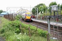 The 1340 Helensburgh Central - Airdrie service (334009)  arrives at Craigendoran at 1343 on a rainy 8 June 2010. The photograph is taken from the trackbed of the line that once branched left here onto the pier platform. The path straight ahead leads to the footbridge and the exit to Station Road beyond the car park. <br><br>[John Furnevel 08/06/2010]