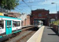 Trafford Bar was the original Old Trafford station, the name change only coming about in 1992 when Warwick Road, outside the cricket ground, was renamed Old Trafford. The original station booking hall still stands above the short tunnel. Two Altrincham services are seen passing here and the station, which enjoys a six minute frequency service, will become even busier when the Didsbury line opens. <br><br>[Mark Bartlett 30/06/2010]