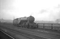 A moody study of V2 2-6-2 no 60886 standing on the King Edward Bridge with the Newcastle skyline in the background. The locomotive spent much of its life on Tyneside before moving to York in 1963, from where it was eventually withdrawn by BR in April of 1966.<br><br>[K A Gray //]