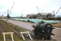 An odd wagon to find at the MK Shand pipe-coating works at Invergordon in 1980. This was for many years a major source of revenue for BR, with trains of 20 wagons and more arriving regularly for coating and then returning south in similar quantities.<br><br>[Frank Spaven Collection (Courtesy David Spaven) //1980]